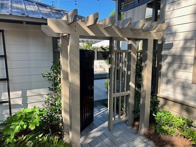 property entrance with metal roof and a pergola