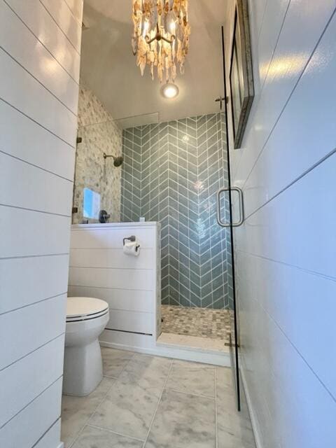 full bath featuring tile patterned flooring, tiled shower, a notable chandelier, and toilet