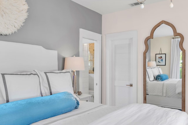 bedroom featuring ensuite bath and visible vents