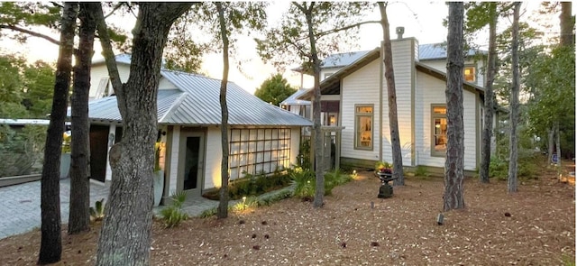 view of side of home with metal roof and a chimney