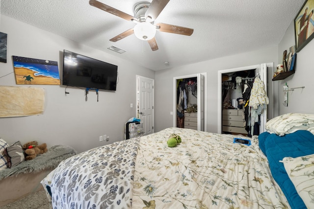 carpeted bedroom with a textured ceiling, a walk in closet, and ceiling fan