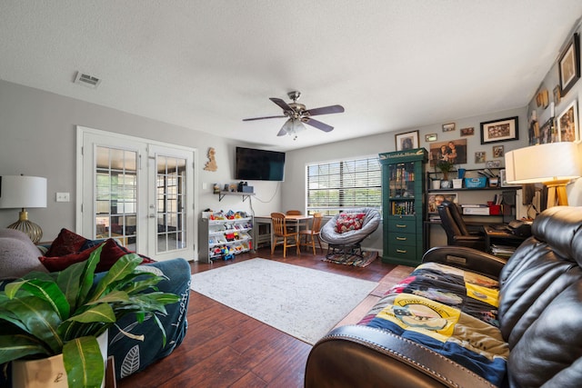 living room featuring french doors, ceiling fan, hardwood / wood-style floors, and a textured ceiling