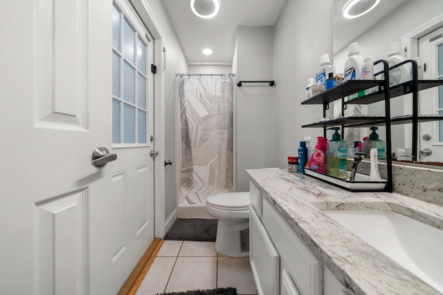 bathroom featuring curtained shower, vanity, tile patterned floors, and toilet