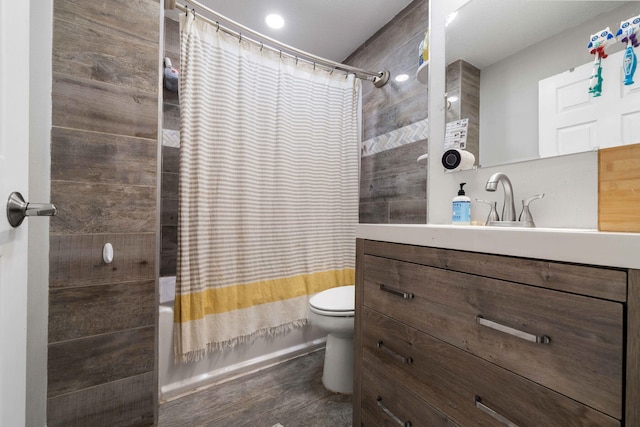 full bathroom with hardwood / wood-style flooring, shower / bath combination with curtain, toilet, and vanity