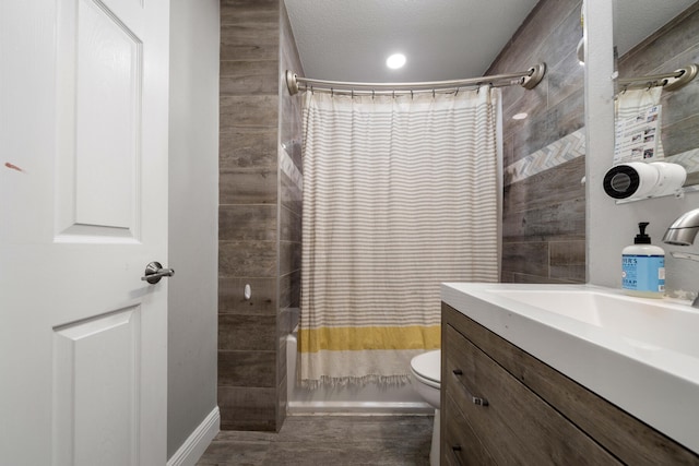 full bathroom featuring shower / bathtub combination with curtain, toilet, vanity, and a textured ceiling