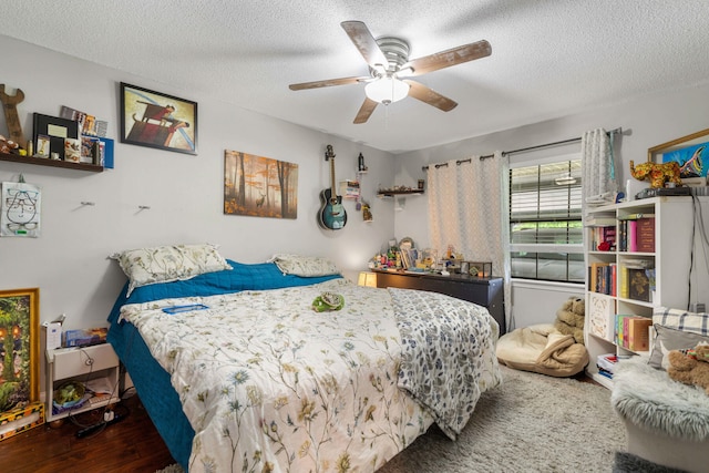 bedroom with a textured ceiling, ceiling fan, and dark hardwood / wood-style floors