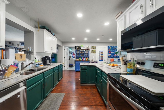 kitchen with white cabinets, dark hardwood / wood-style flooring, stainless steel appliances, green cabinets, and sink