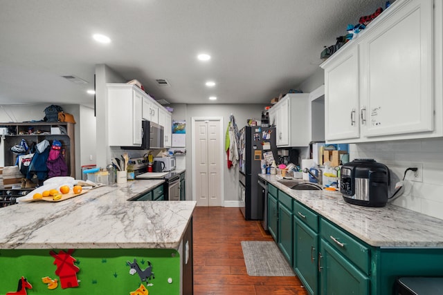 kitchen featuring appliances with stainless steel finishes, sink, dark hardwood / wood-style floors, green cabinets, and white cabinetry