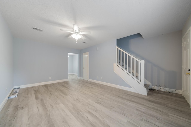 unfurnished living room featuring ceiling fan, a textured ceiling, and light hardwood / wood-style flooring