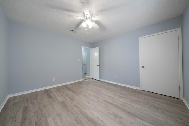 unfurnished room featuring a textured ceiling, light hardwood / wood-style flooring, and ceiling fan