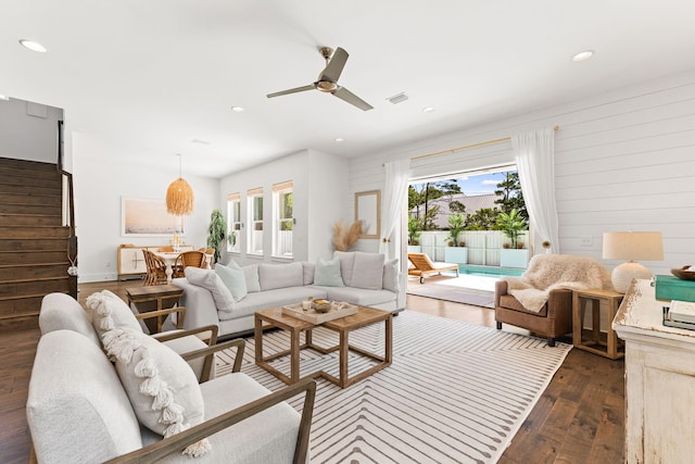 living room featuring dark wood-type flooring and ceiling fan