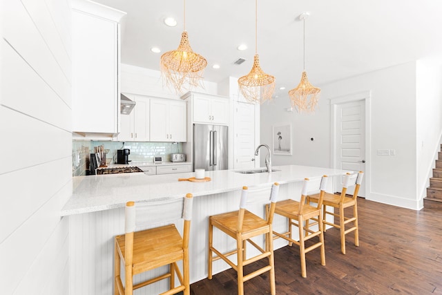 kitchen featuring high end fridge, dark hardwood / wood-style flooring, white cabinets, sink, and backsplash