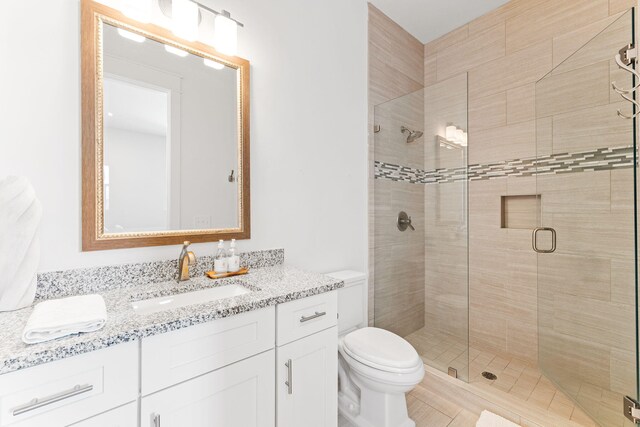 bathroom with vanity, an enclosed shower, and toilet