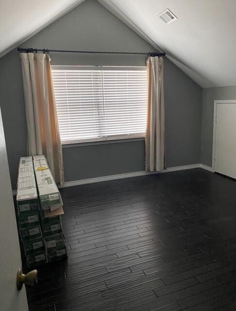 bonus room with wood-type flooring and vaulted ceiling