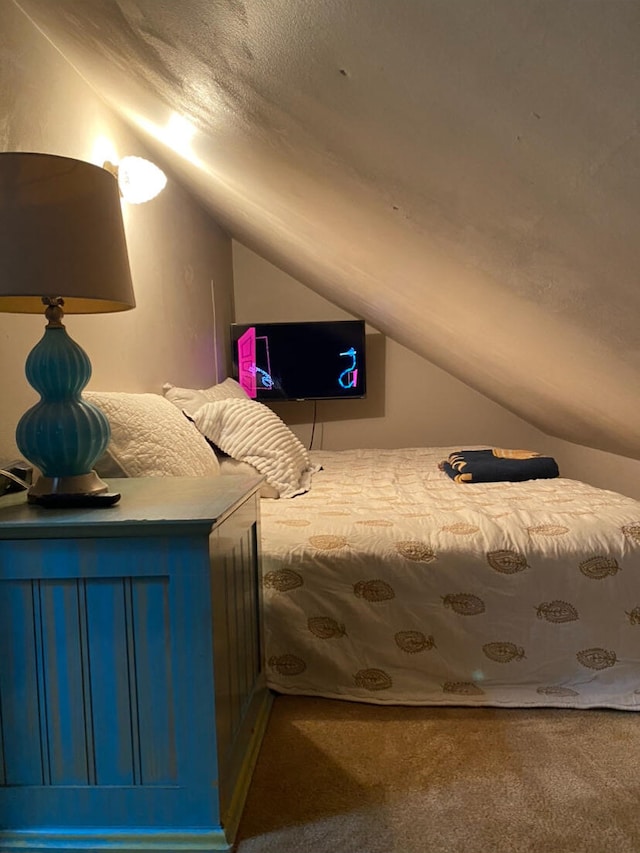 unfurnished bedroom featuring carpet and vaulted ceiling