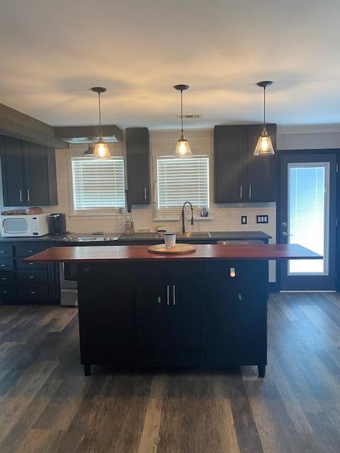 kitchen with backsplash, dark hardwood / wood-style floors, sink, and decorative light fixtures