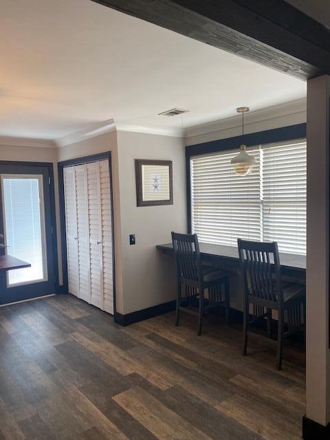 dining space with dark hardwood / wood-style floors and ornamental molding