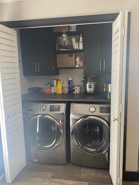 laundry area with cabinets, dark hardwood / wood-style flooring, and independent washer and dryer