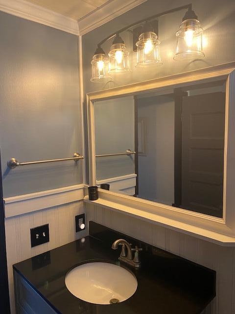 bathroom with ornamental molding and sink