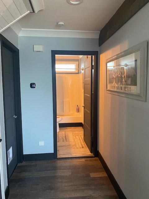 corridor with crown molding and hardwood / wood-style flooring