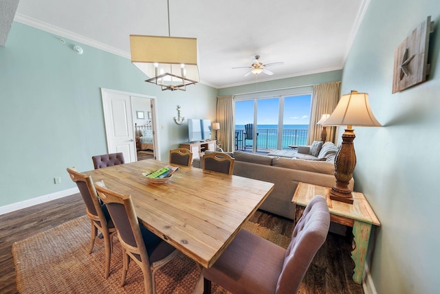 dining space with baseboards, wood finished floors, ceiling fan with notable chandelier, and crown molding