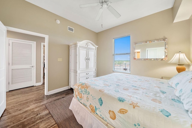bedroom featuring dark wood-style flooring, baseboards, ceiling fan, and visible vents