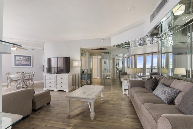 living room with visible vents, ceiling fan, baseboards, and wood finished floors