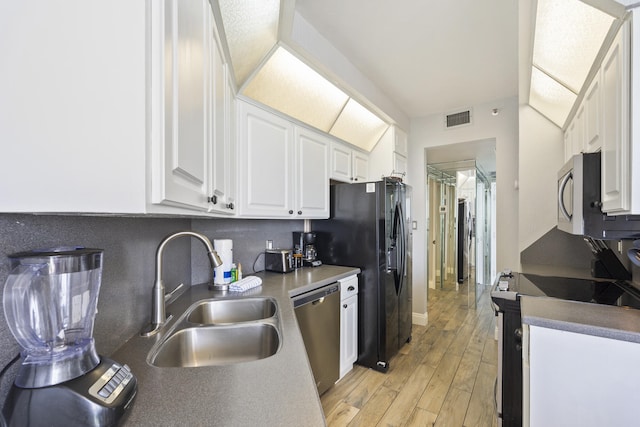 kitchen featuring stainless steel appliances, visible vents, decorative backsplash, white cabinetry, and a sink