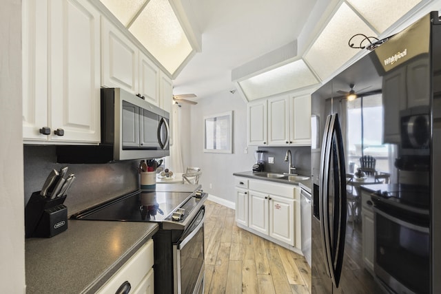 kitchen with stainless steel appliances, dark countertops, and white cabinets