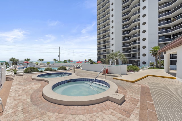 view of pool with a community hot tub and a patio