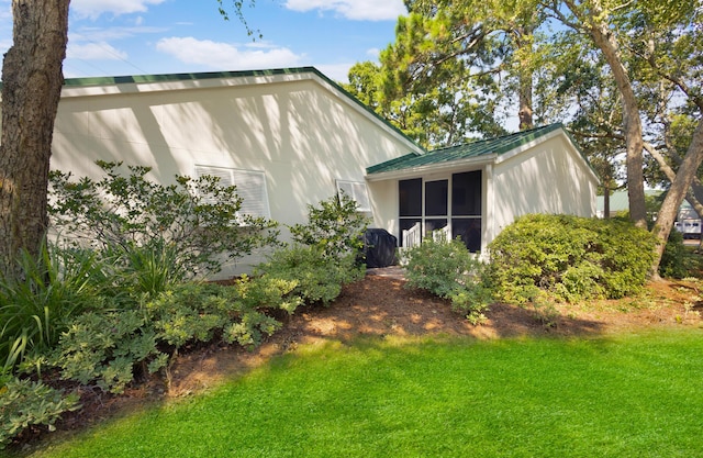 exterior space with a lawn and a sunroom