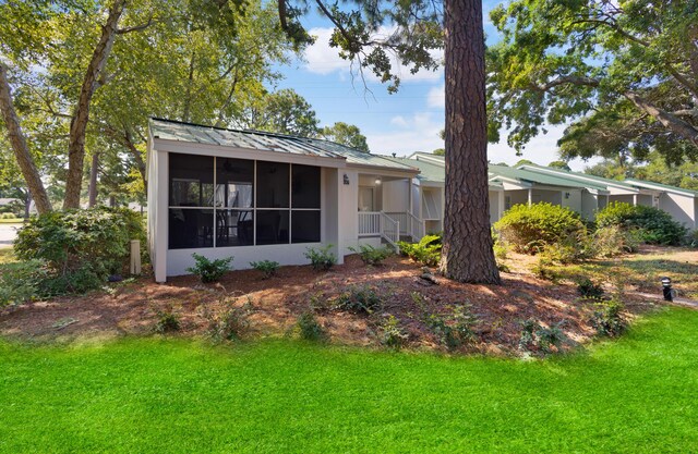 view of front of home featuring a sunroom and a front lawn