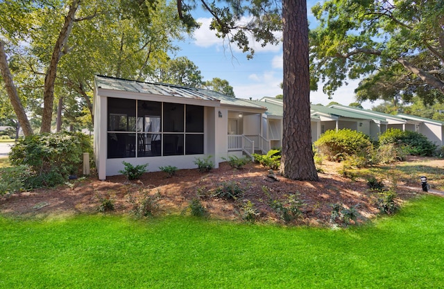 exterior space featuring a sunroom and a lawn