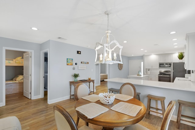 dining room featuring a chandelier and light wood-type flooring