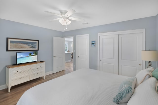 bedroom featuring ceiling fan, dark hardwood / wood-style flooring, and a closet