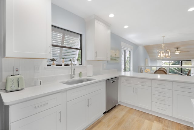 kitchen with sink, light hardwood / wood-style flooring, white cabinets, decorative light fixtures, and stainless steel dishwasher