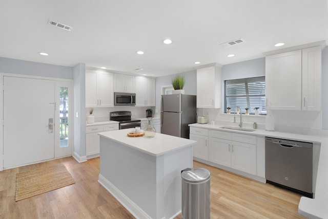 kitchen with appliances with stainless steel finishes, sink, and white cabinets