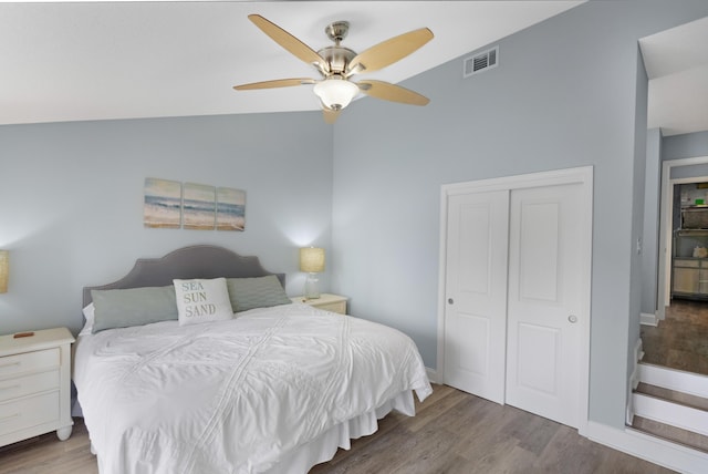 bedroom featuring lofted ceiling, hardwood / wood-style flooring, a closet, and ceiling fan