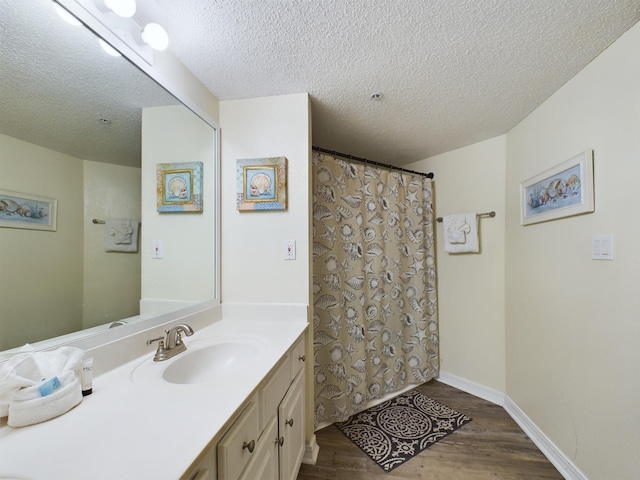 790 Santa Rosa Blvd Unit 3009, Fort Walton Beach, FL 32548 - full bathroom featuring baseboards, wood finished floors, vanity, and a textured ceiling