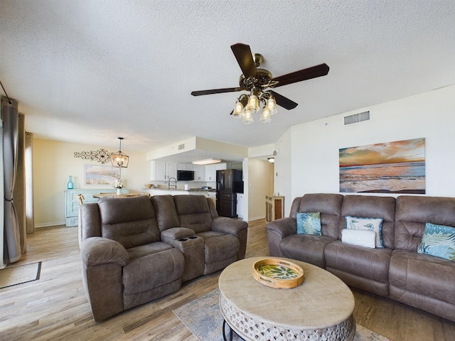 790 Santa Rosa Blvd Unit 3009, Fort Walton Beach, FL 32548 - living room with a ceiling fan, a textured ceiling, baseboards, visible vents, and light wood-style floors