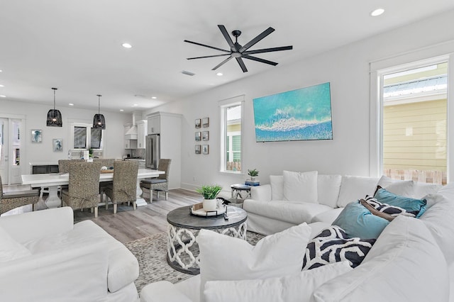 living room with ceiling fan and light wood-type flooring