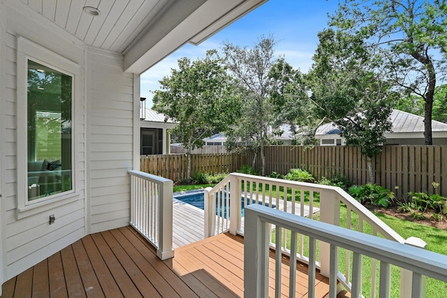 wooden deck with a fenced in pool