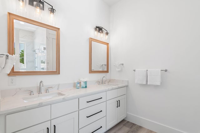 bathroom featuring dual bowl vanity and hardwood / wood-style flooring