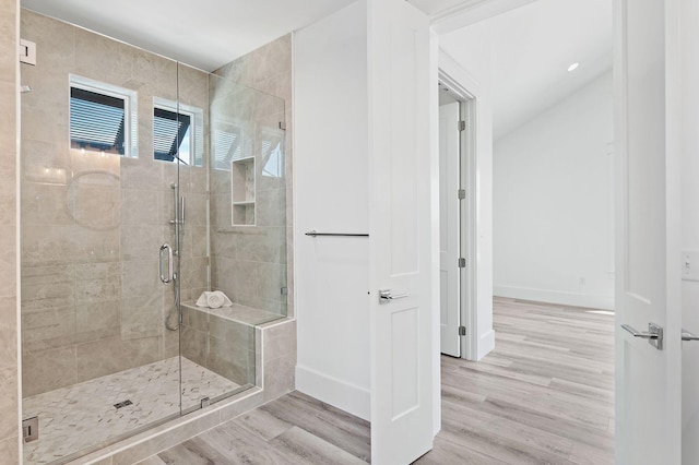 bathroom with a shower with door and hardwood / wood-style floors