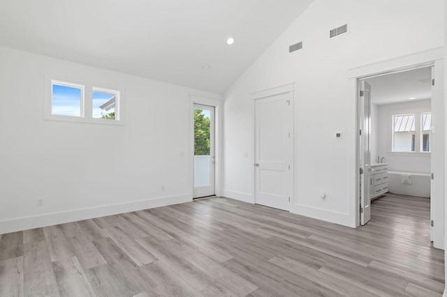 unfurnished bedroom with ensuite bath, high vaulted ceiling, and light hardwood / wood-style flooring