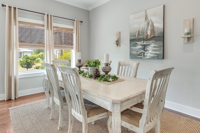 dining area with crown molding and light hardwood / wood-style floors