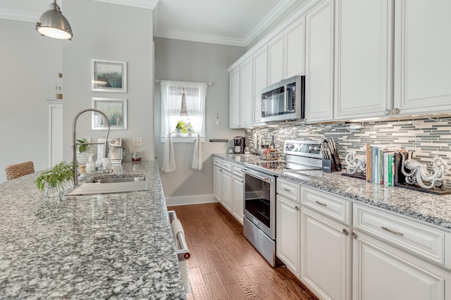 kitchen featuring appliances with stainless steel finishes, backsplash, white cabinets, sink, and dark wood-type flooring