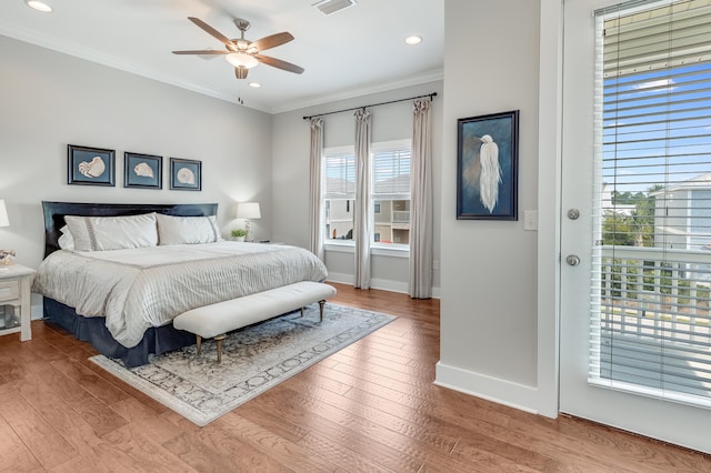 bedroom with ceiling fan, multiple windows, hardwood / wood-style floors, and crown molding