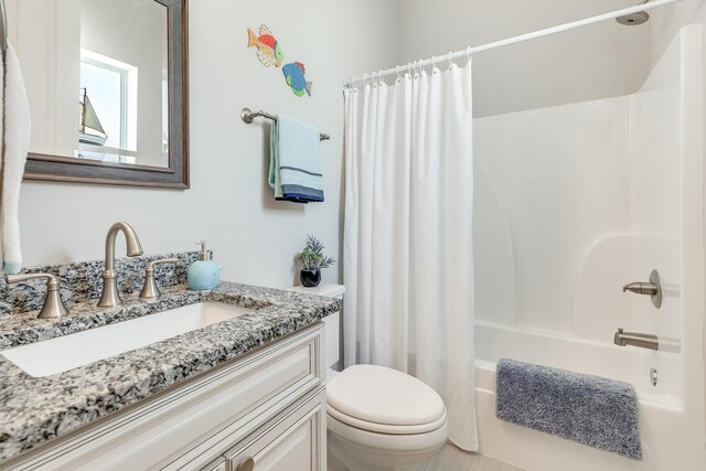 full bathroom featuring shower / bath combo with shower curtain, vanity, and toilet