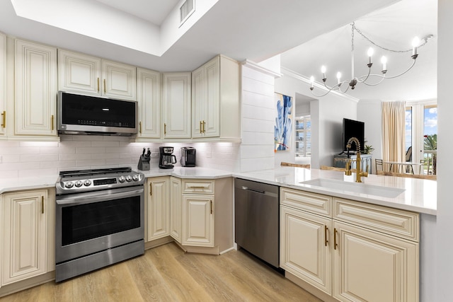 kitchen with sink, appliances with stainless steel finishes, and cream cabinets